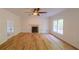 Bright living room features a stone fireplace, hardwood floors, ceiling fan and wainscoting for a traditional look at 731 Sacketts Ct, Lawrenceville, GA 30043