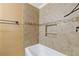 Tiled bathtub and shower with built-in shelf niche and decorative tile detail at 992 Estes Sw Dr, Atlanta, GA 30310