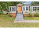 Close-up of a cozy home highlighting the inviting orange front door and well-manicured landscaping at 992 Estes Sw Dr, Atlanta, GA 30310
