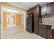 Kitchen with dark cabinets and stainless steel refrigerator with dining area and front door in background at 992 Estes Sw Dr, Atlanta, GA 30310