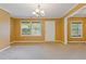Bright living area featuring neutral carpet, fresh paint, and natural light from large windows at 992 Estes Sw Dr, Atlanta, GA 30310
