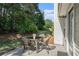 Outdoor patio area with furniture, surrounded by green grass and beautiful landscaping, creating a peaceful retreat at 1180 Chandler Ridge Dr, Lawrenceville, GA 30045