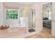 Bathroom featuring a large tub, separate shower, and access to the main bedroom at 1180 Chandler Ridge Dr, Lawrenceville, GA 30045