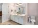 Bright bathroom featuring double sinks, ample counter space, a toilet, and white cabinets at 1180 Chandler Ridge Dr, Lawrenceville, GA 30045