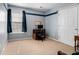 Neutral-toned bedroom with carpeted floor features a desk, chair, and window with natural light at 1180 Chandler Ridge Dr, Lawrenceville, GA 30045
