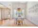 Elegant dining room with a designer light fixture, wainscoting, and large windows that flood the room with natural light at 1180 Chandler Ridge Dr, Lawrenceville, GA 30045
