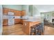 Functional kitchen with wood cabinets, white appliances, and breakfast bar opening to the cozy living area at 1180 Chandler Ridge Dr, Lawrenceville, GA 30045