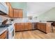 Well-lit kitchen featuring wood cabinetry, white appliances, and an efficient layout at 1180 Chandler Ridge Dr, Lawrenceville, GA 30045