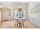 Bright dining room with a unique light fixture, wainscoting, and views of the front door at 1180 Chandler Ridge Se Dr, Lawrenceville, GA 30045