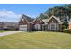 Attractive brick home with a lush green lawn, driveway, and meticulously maintained landscaping at 1180 Chandler Ridge Se Dr, Lawrenceville, GA 30045