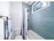 Modern bathroom with blue tiled walls, shower and bath with a window view at 1676 Carroll Nw Dr, Atlanta, GA 30318