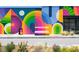 Community gathering spot with a colorful mural on building, a bench and floral landscape at 1676 Carroll Nw Dr, Atlanta, GA 30318