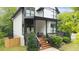 Inviting covered front porch with stylish railings, steps, seating, and lush landscaping at 1676 Carroll Nw Dr, Atlanta, GA 30318