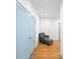 Hallway with hardwood floors, chair with footstool, and blue painted doors at 1676 Carroll Nw Dr, Atlanta, GA 30318
