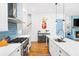 Bright kitchen features stainless steel appliances, range hood, marble counters, and blue backsplash at 1676 Carroll Nw Dr, Atlanta, GA 30318