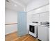 Modern laundry room with full-sized washer and dryer, open shelving and wood floors at 1676 Carroll Nw Dr, Atlanta, GA 30318