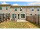 A fenced backyard of a townhouse with a small patio and lawn at 2142 Arnage Dr, Lithonia, GA 30058