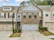 Charming townhome featuring a brick facade, two-car garage, and manicured landscaping at 2142 Arnage Dr, Lithonia, GA 30058