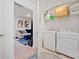 Bright laundry room with modern washer and dryer, plus shelving and a glimpse into a cozy living space at 2142 Arnage Dr, Lithonia, GA 30058