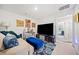 Cozy living room featuring a comfortable couch, blue ottoman, and a peek into the hallway at 2142 Arnage Dr, Lithonia, GA 30058