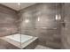 A luxurious bathroom featuring a soaking tub and a glass enclosed shower with decorative tile at 222 12Th Ne St # 1806, Atlanta, GA 30309