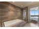 A luxurious bathroom featuring a soaking tub and a glass enclosed shower with wood-look tile at 222 12Th Ne St # 1806, Atlanta, GA 30309
