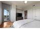 Modern bedroom with private balcony access, flatscreen television, wood floors, and neutral decor at 222 12Th Ne St # 1806, Atlanta, GA 30309