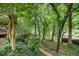 Lush backyard with mature trees leading down to a serene lake, offering a peaceful retreat at 4754 Kelley Se Ct, Mableton, GA 30126