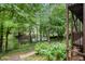 A view of the backyard from the porch, with trees, plants, and lake in the background at 4754 Kelley Se Ct, Mableton, GA 30126