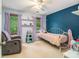 This bedroom features blue walls, two windows, chair, shelves, and a ceiling fan at 4754 Kelley Se Ct, Mableton, GA 30126