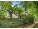 A full view of the exterior of the house from below the hill and surrounded by greenery at 4754 Kelley Se Ct, Mableton, GA 30126