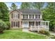 Charming two-story home with a stone facade and a welcoming front porch, nestled among lush trees and landscaping at 4754 Kelley Se Ct, Mableton, GA 30126