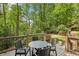 Scenic back deck boasts a round table and four chairs offering a great space to relax and enjoy the wooded views at 1050 Mountain Creek Trl, Atlanta, GA 30328