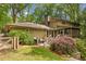 View of a well-maintained home exterior with a deck, screened porch, lush landscaping, and a wooden privacy fence at 1050 Mountain Creek Trl, Atlanta, GA 30328