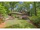 Spacious backyard featuring a well-maintained lawn, mature trees, and a screened-in porch at 1050 Mountain Creek Trl, Atlanta, GA 30328
