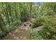 A backyard fire pit with four chairs creates an intimate setting surrounded by a lush wooded area at 1050 Mountain Creek Trl, Atlanta, GA 30328