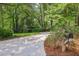 Long driveway to a beautiful home surrounded by lush greenery and mature trees at 1050 Mountain Creek Trl, Atlanta, GA 30328