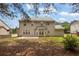 Expansive backyard featuring a well-maintained lawn and a two-story home with multiple windows and a patio at 110 Village Green Cir, Tyrone, GA 30290