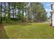 Lush backyard featuring a well-maintained lawn with trees on a sunny day at 110 Village Green Cir, Tyrone, GA 30290