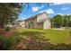 View of a spacious backyard with a lush lawn, trees, and a glimpse of the adjacent home at 110 Village Green Cir, Tyrone, GA 30290