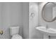 Cozy half-bathroom featuring a pedestal sink, modern fixtures, and a standard toilet at 110 Village Green Cir, Tyrone, GA 30290