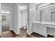 Hall bathroom featuring a white vanity with a sink, and an adjacent bathroom with a tub at 110 Village Green Cir, Tyrone, GA 30290