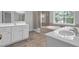 Bathroom featuring a tub, glass shower, dual vanities, and tile flooring at 110 Village Green Cir, Tyrone, GA 30290