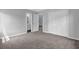 Bedroom with neutral walls, plush carpeting, and a closet and bathroom accessible through doors at 110 Village Green Cir, Tyrone, GA 30290