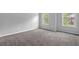 Cozy bedroom with neutral walls, soft carpet, and double windows at 110 Village Green Cir, Tyrone, GA 30290