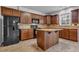Bright kitchen featuring wooden cabinets, granite countertops, a black refrigerator, and a central island at 110 Village Green Cir, Tyrone, GA 30290