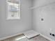 A practical laundry room featuring a tiled floor, utility sink, window, and hookups for a washer and dryer at 110 Village Green Cir, Tyrone, GA 30290