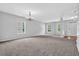 Spacious living room featuring neutral carpet, paint, and large windows at 110 Village Green Cir, Tyrone, GA 30290