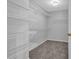Spacious walk-in closet with multiple shelves for optimal storage in this functional space at 110 Village Green Cir, Tyrone, GA 30290