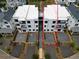 An aerial view of a modern, three-story townhouse with a private driveway, enclosed by a light wood fence at 11548 Serenbe Ln, Chattahoochee Hills, GA 30268